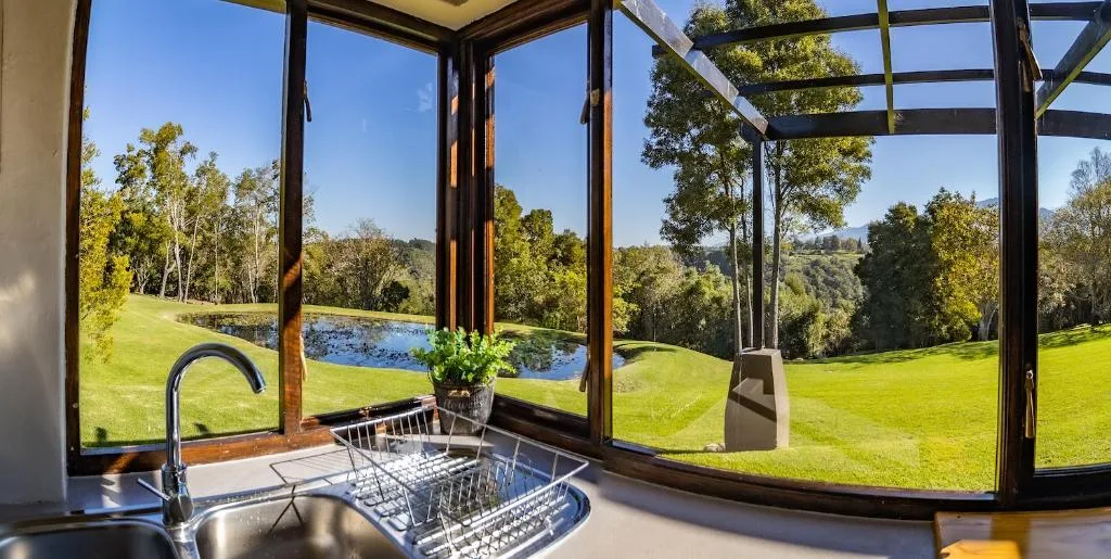 Modern kitchen sink with expansive views of manicured gardens and pond