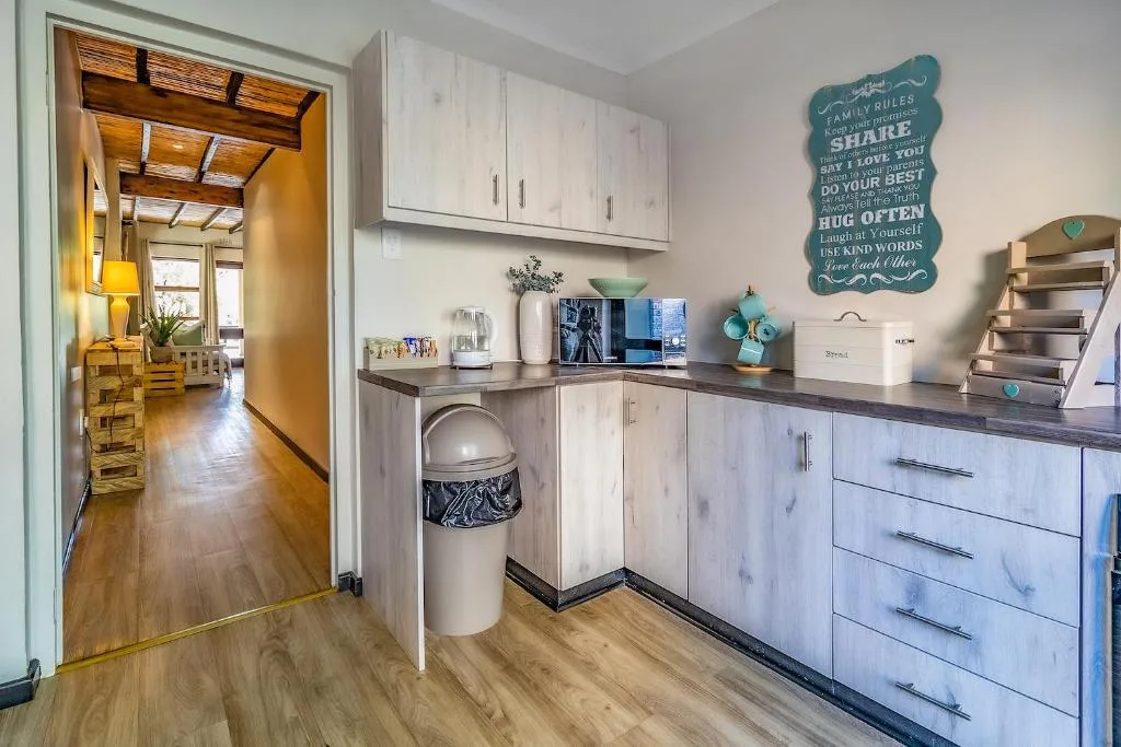 Modern kitchen with white cabinetry, dark countertops, and turquoise decor accents