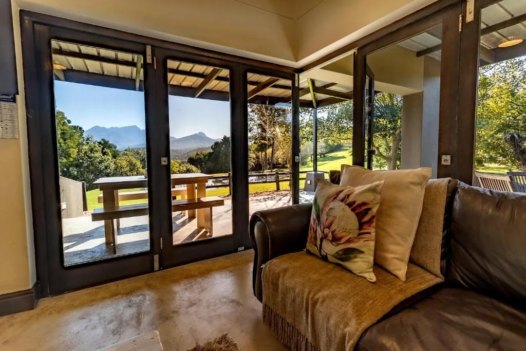 Spacious lounge with sofa and mountain views through glass doors