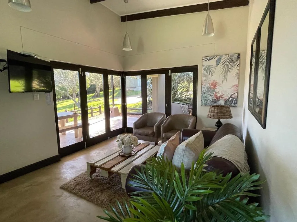 Bright lounge with leather seating, folding doors opening to garden views