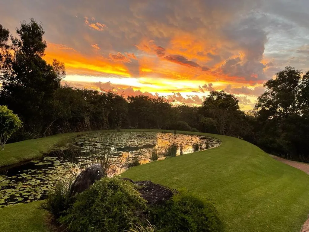Dramatic sunset over manicured gardens and ornamental pond at dusk