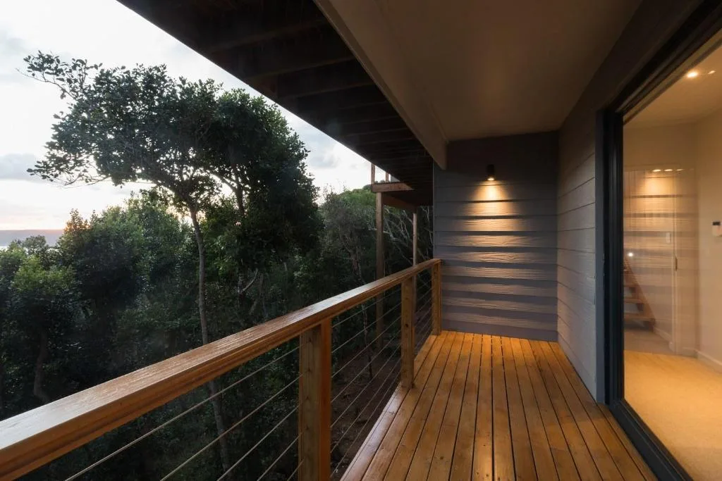 Modern wooden deck with cable railing overlooking forest and distant views