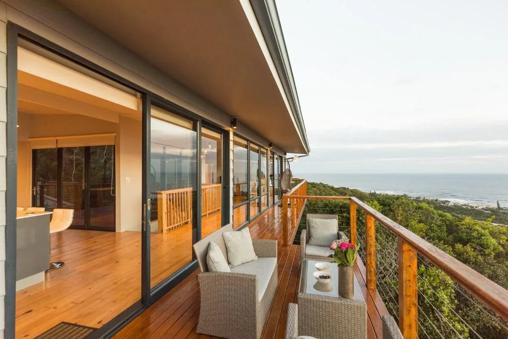 Wooden deck with comfortable seating overlooking coastal forest and ocean views