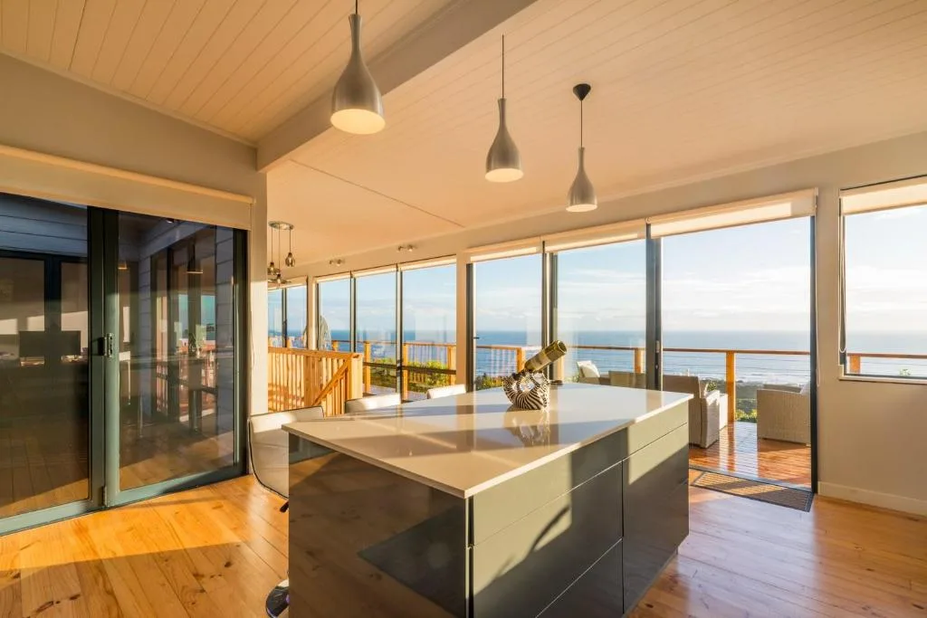 Modern kitchen with island overlooking ocean views through large windows