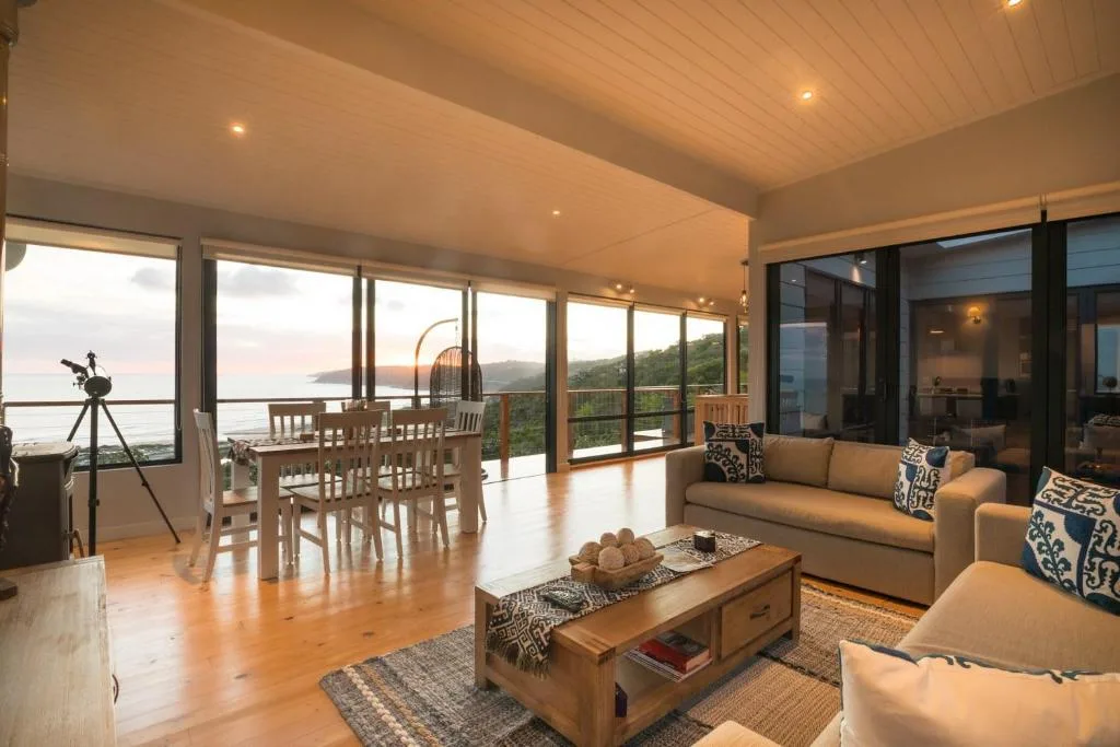 Spacious lounge with ocean views, sofa seating, and panoramic windows
