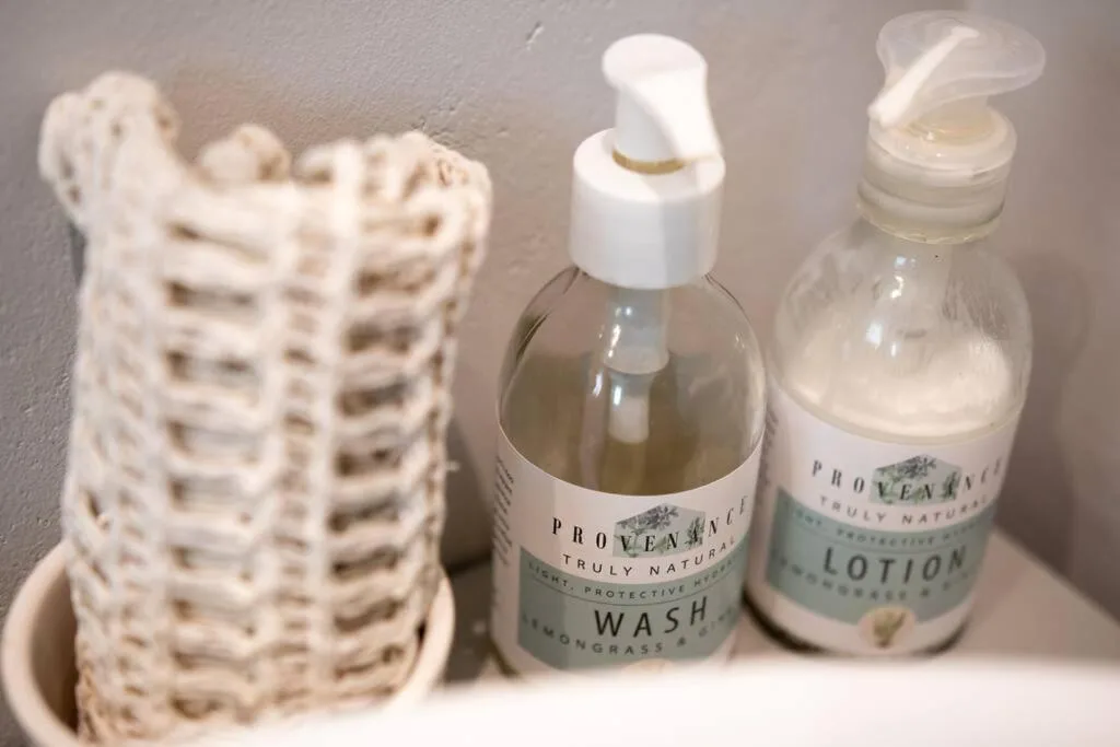 Bathroom toiletries including natural wash and lotion bottles with lemongrass