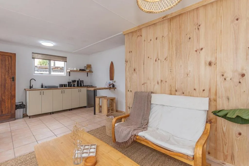 Open-plan kitchen and living area with wooden walls and modern amenities