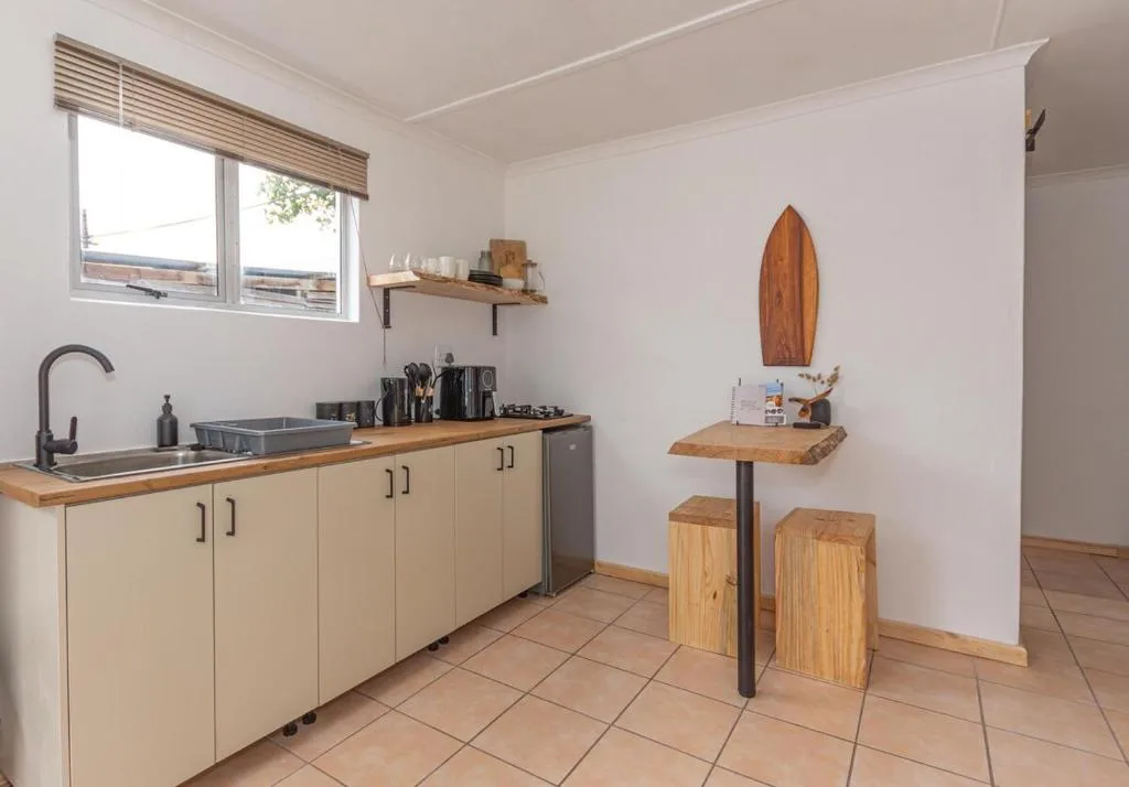 Light kitchen with wooden countertops, cream cabinetry, and black sink fixture