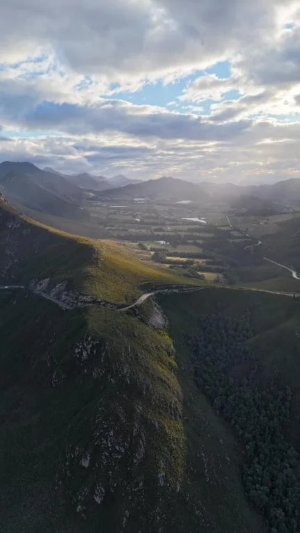 Aerial view of verdant valley with winding river and distant mountains