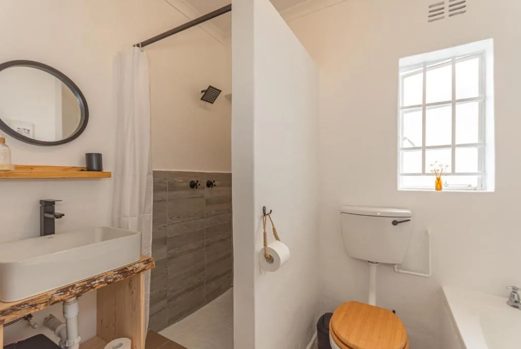 Modern bathroom with walk-in shower, vessel sink, and bright window