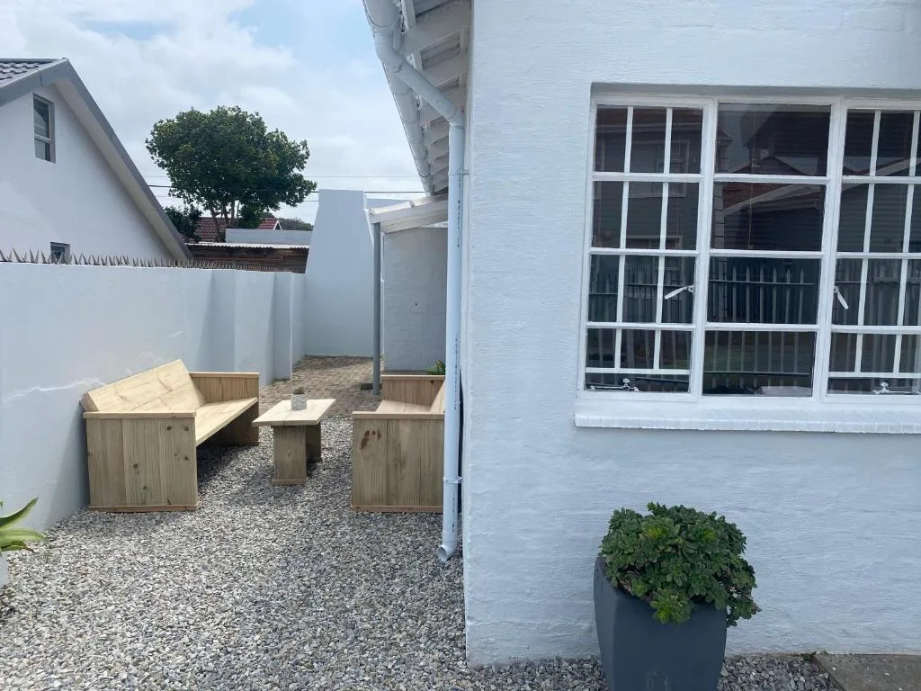 Wooden seating area with benches and table in courtyard space