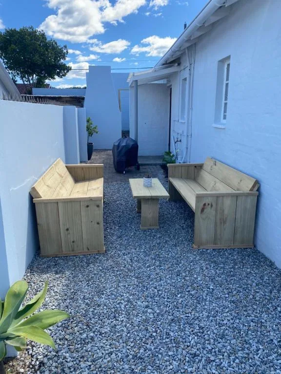 Outdoor courtyard with wooden benches and small table on gravel