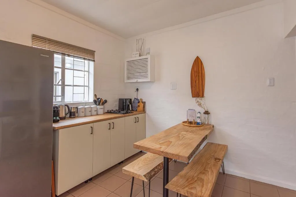 Modern kitchen with cream cabinetry, wooden counters, and stainless steel appliances