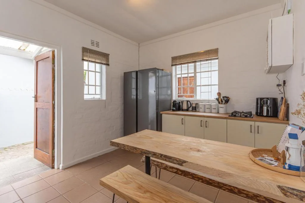 Spacious kitchen with wooden dining table, cream cabinetry, and dark refrigerator