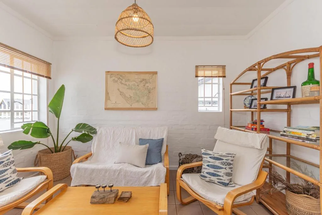 Bright lounge with wooden furniture, woven pendant light, and coastal decor