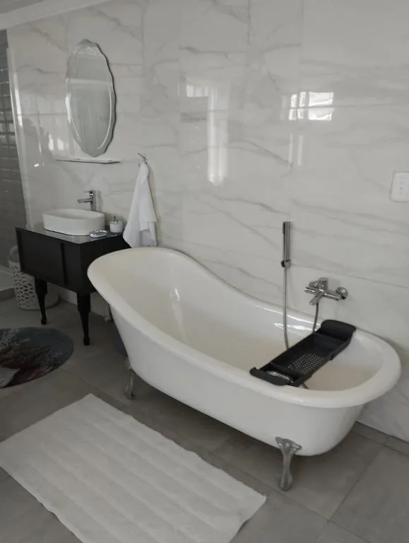 Modern bathroom with freestanding white bathtub and black vanity sink