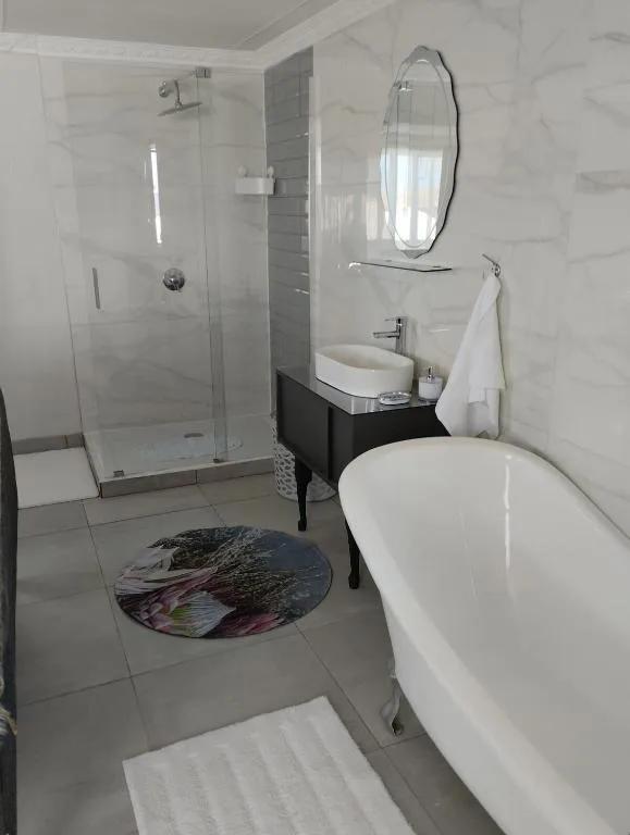 Modern bathroom with freestanding tub, rainfall shower, and marble tiling