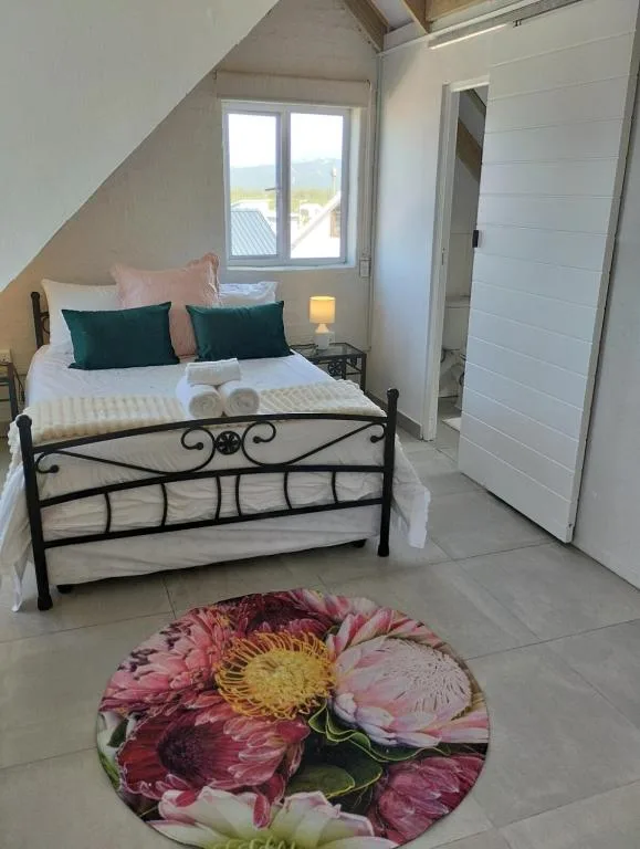 Bright bedroom with black metal bed frame and scenic view through windows