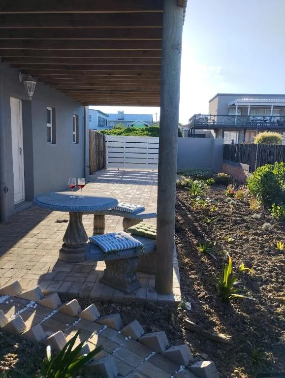 Covered patio area with blue round table and garden views