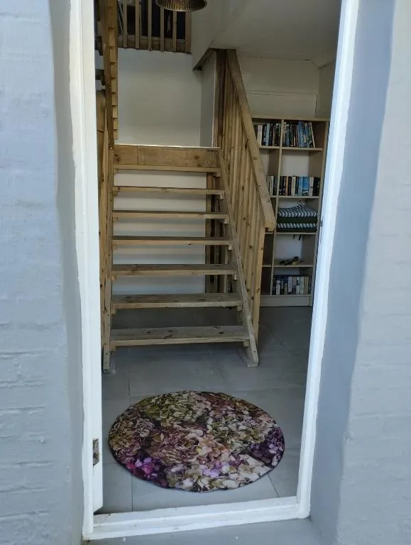 Wooden staircase with built-in shelving and decorative rug entrance