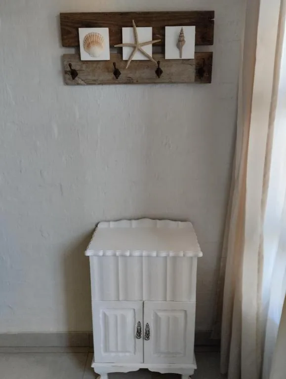 Coastal-themed wall decor with driftwood shelf and seashell artwork