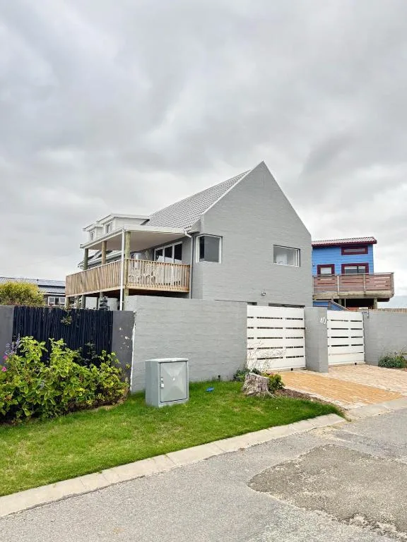 Modern gray holiday home with upper deck and white garage doors, Wilderness