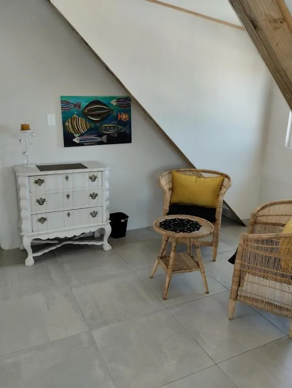 Bright lounge area with wicker chairs and white vintage dresser