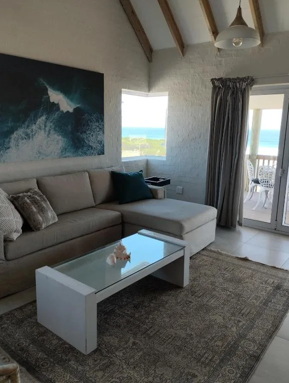 Modern living room with gray sofa, ocean view through windows, and contemporary decor