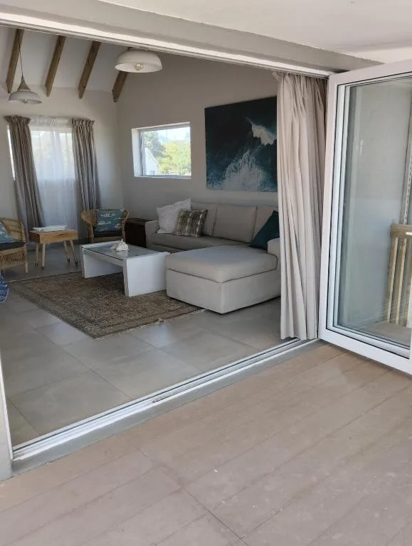 Modern living room with grey sofa, white coffee table, and mountain artwork