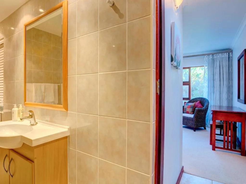 Modern bathroom with wooden vanity, mirror, and large shower enclosure