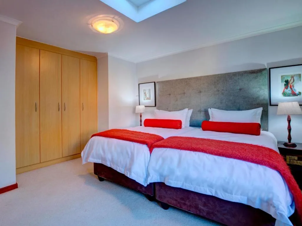 Modern bedroom with queen bed, red runner, wooden wardrobes, skylight