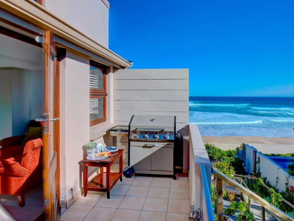 Beachfront deck with braai, outdoor seating, ocean view beyond
