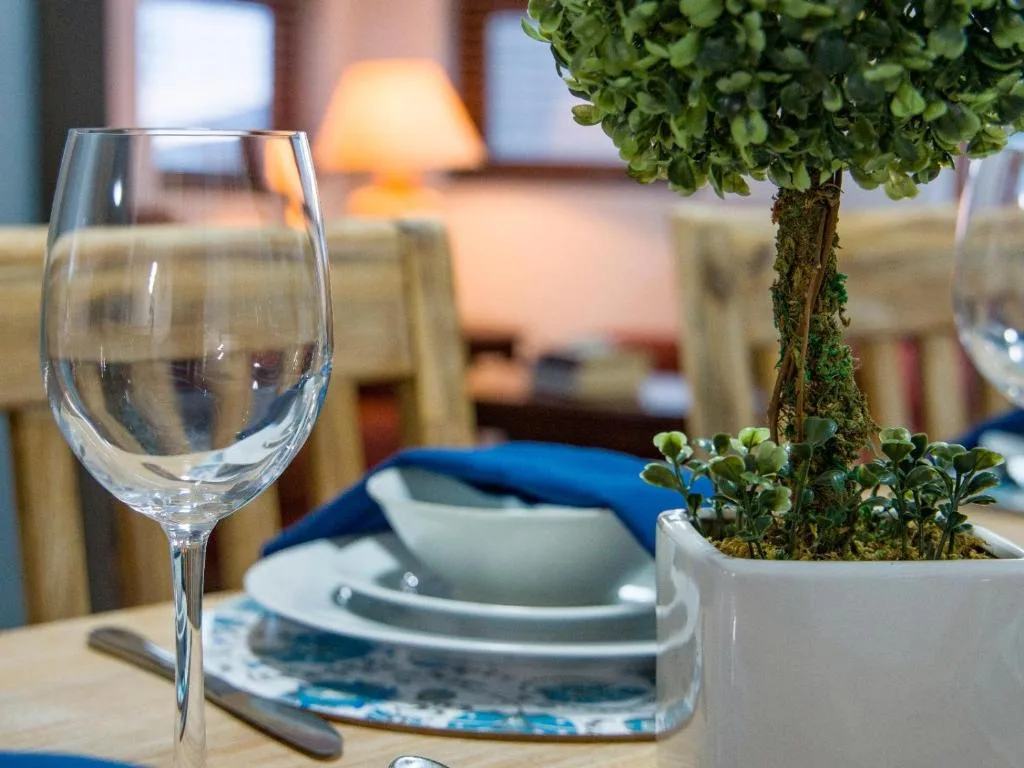 Elegant dining table setting with wine glass and potted plant decoration