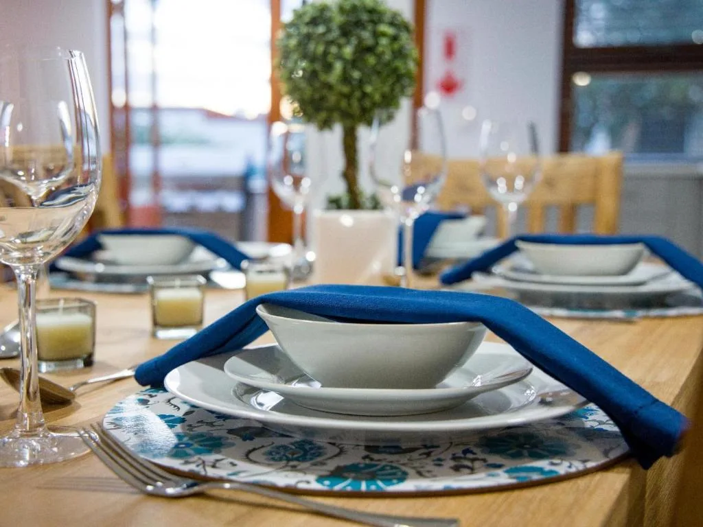 Elegant dining table set with blue napkins, white plates, and glassware