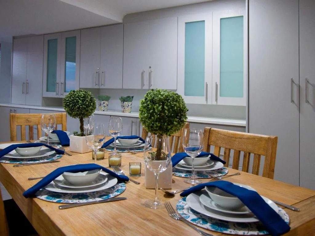 Dining table set for guests with blue napkins and glassware