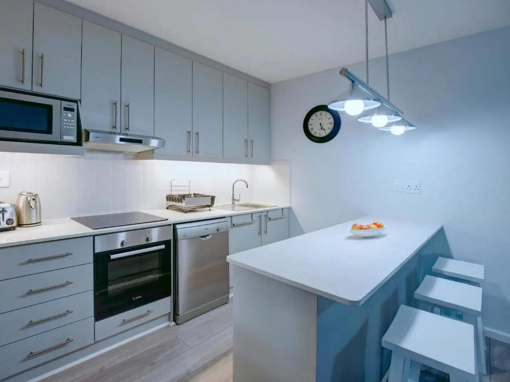Modern kitchen with light cabinetry, island counter, and stainless steel appliances