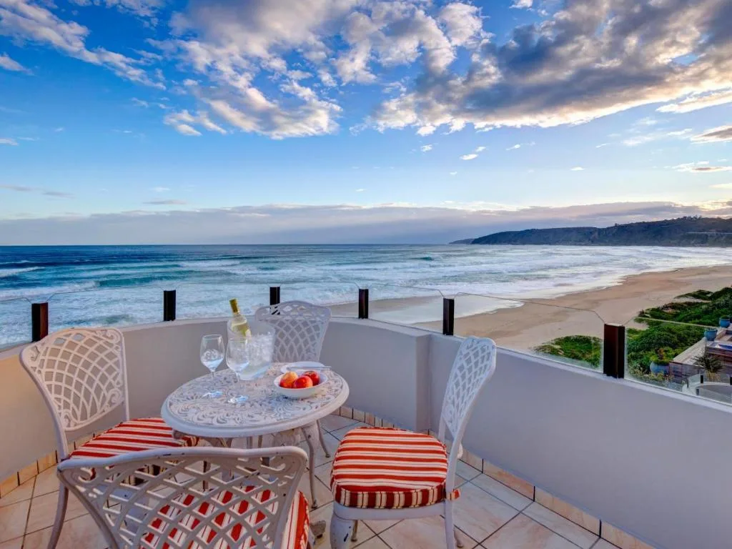 Beachfront ocean view from a private deck with dining setup