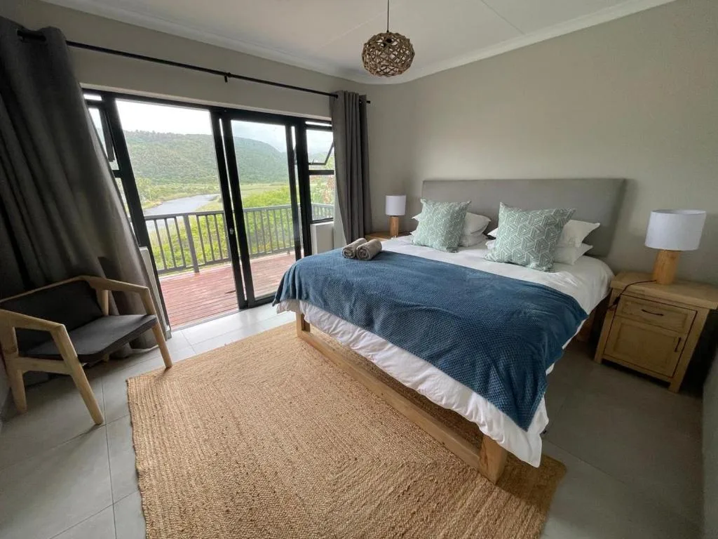 Spacious bedroom with mountain views through glass doors to deck