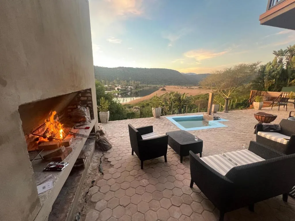 Outdoor patio with fireplace, seating, and scenic river valley views