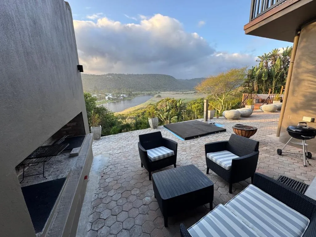 Patio with seating and braai overlooking lagoon and mountains