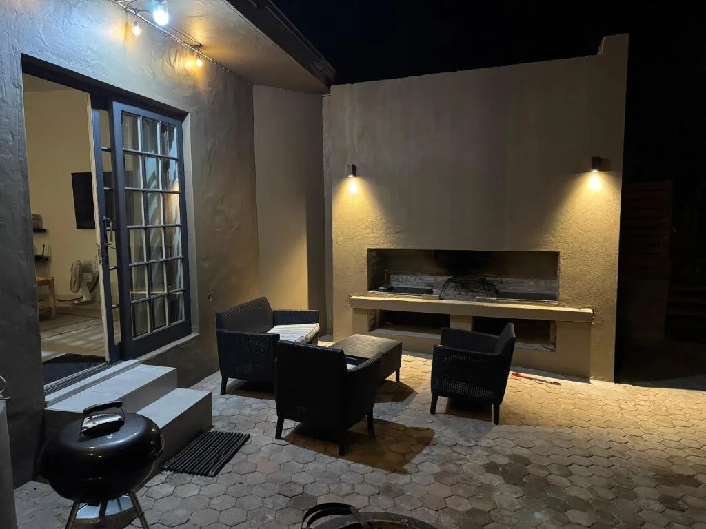 Outdoor patio with seating area and fireplace at night