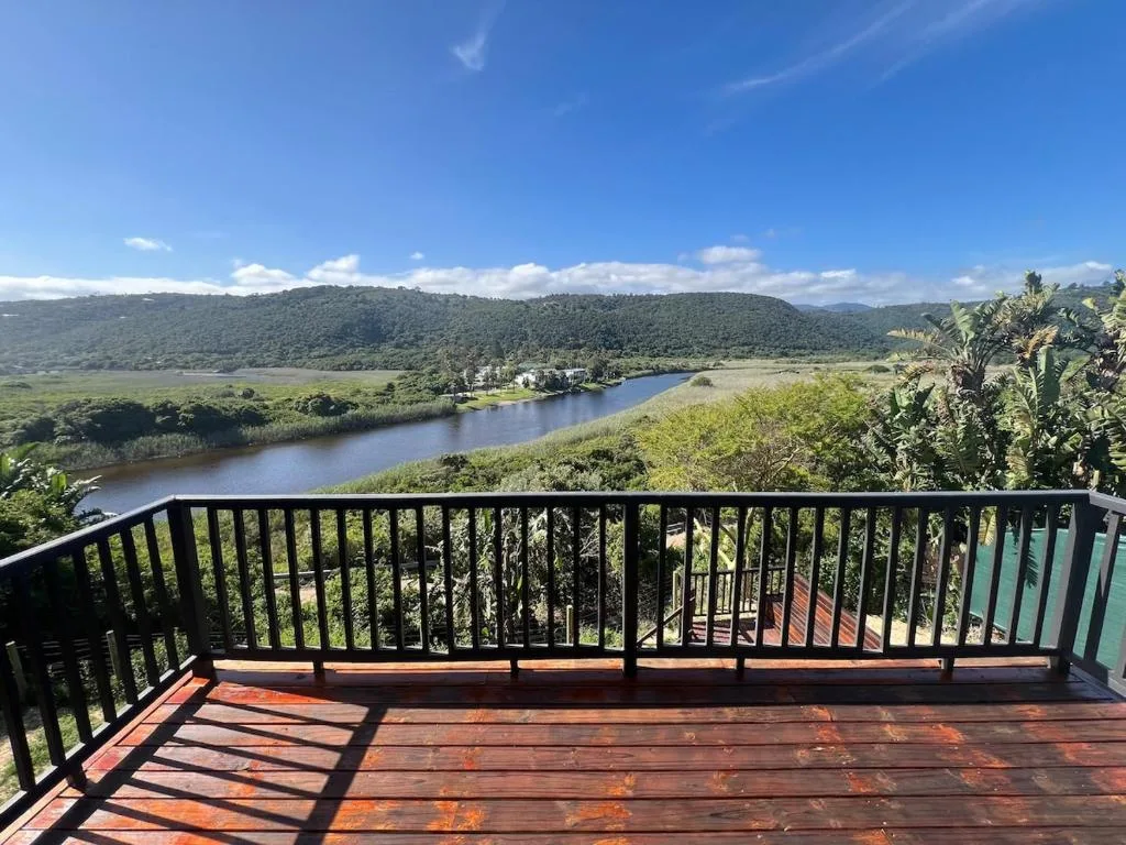 Scenic river valley with forested mountains and lush green landscape