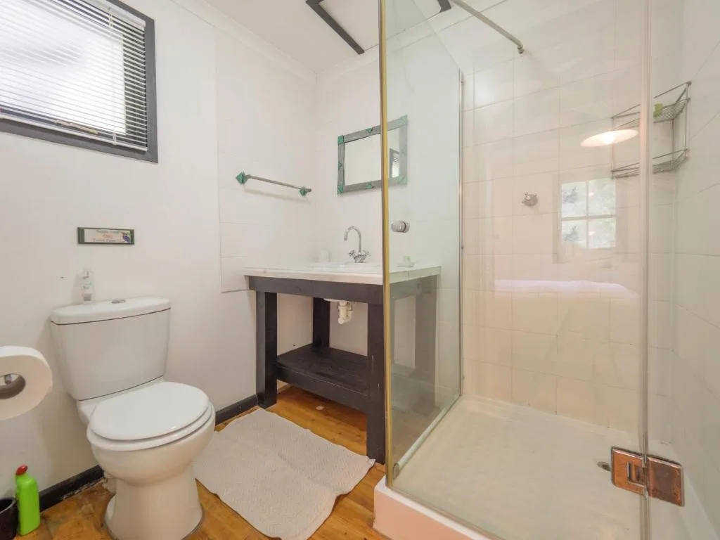 Modern bathroom with glass shower, vanity sink, and white toilet fixtures