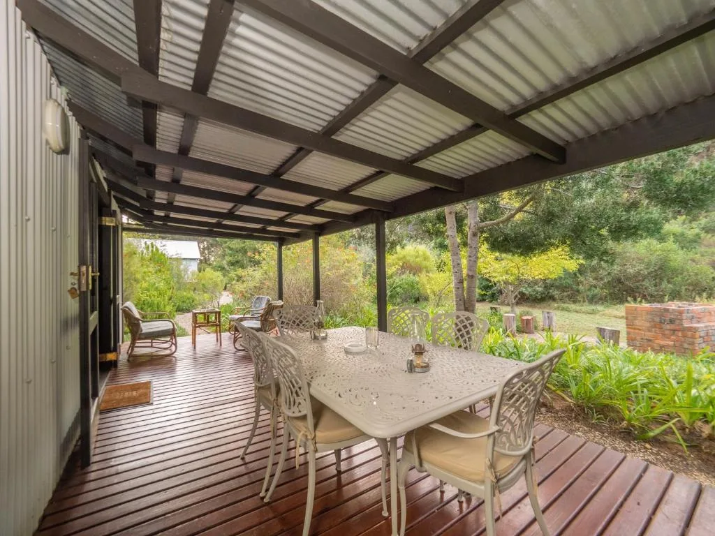 Covered outdoor patio with dining table and garden views