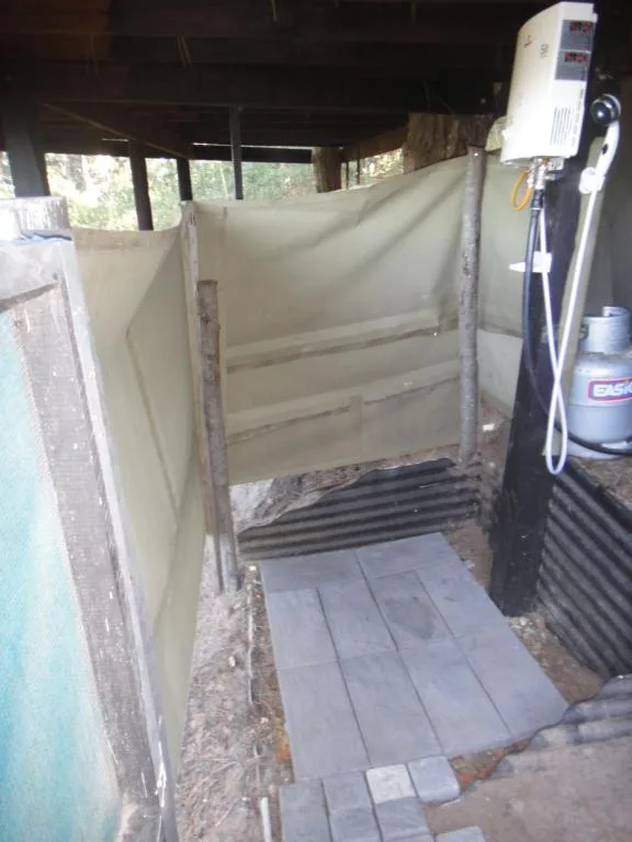 Outdoor shower enclosure with cream walls and tile flooring