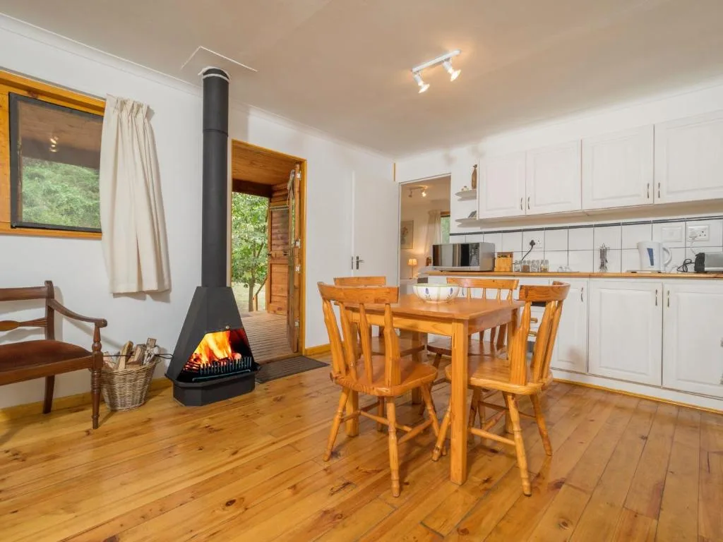 Open-plan dining area with wooden table, chairs, and fireplace