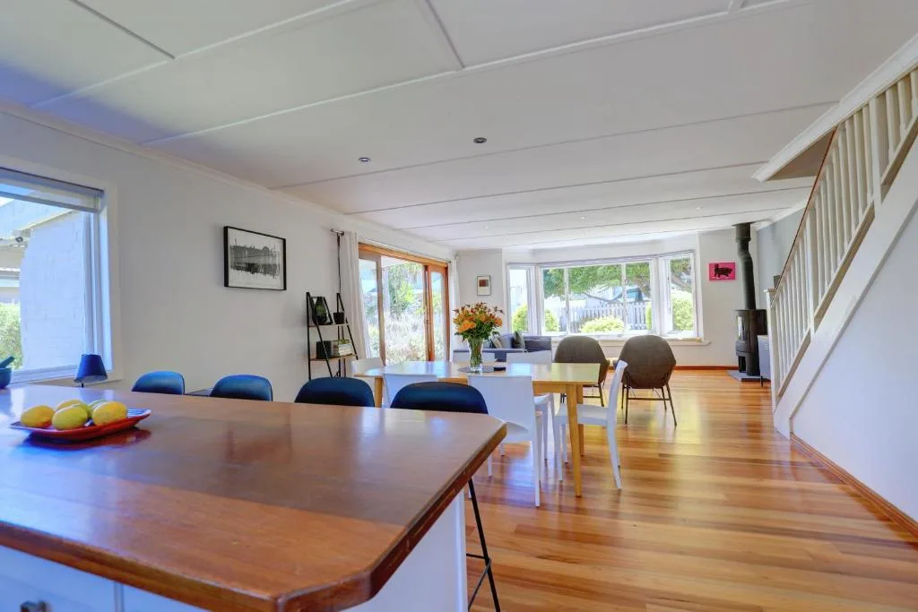 Spacious open-plan dining area with wooden table and blue chairs