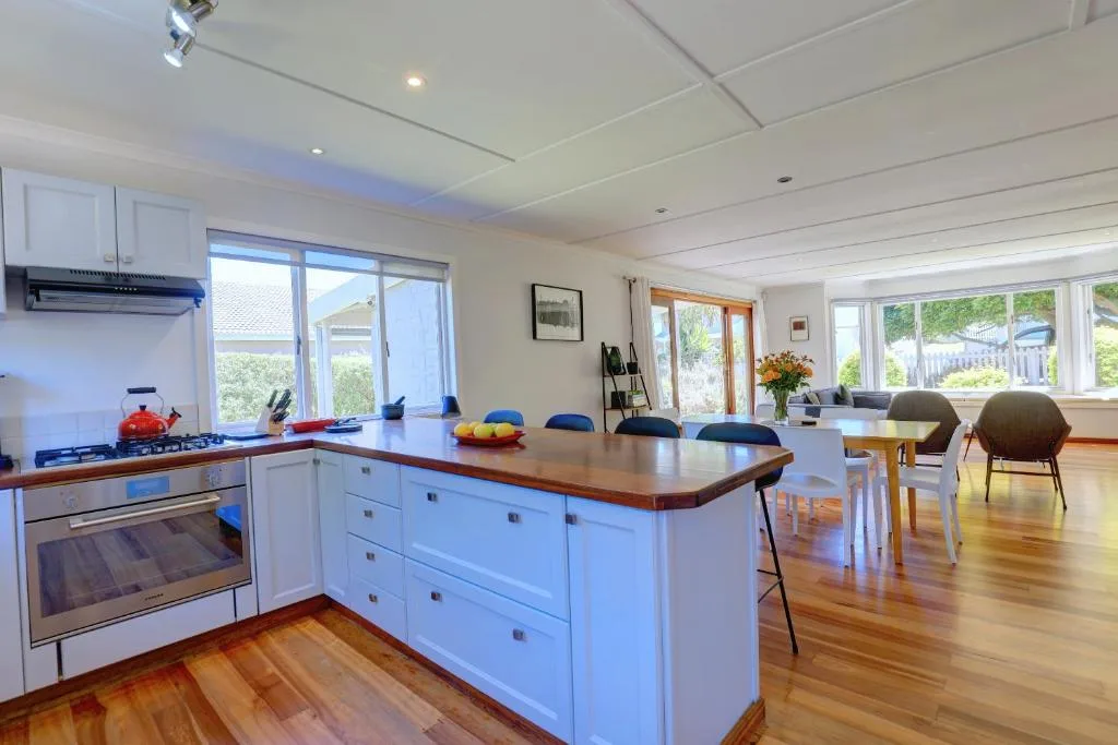 Modern kitchen with white cabinetry, island counter, and wooden flooring