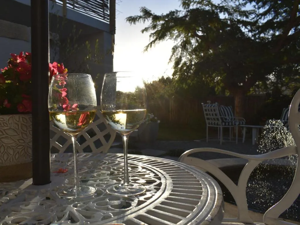 Wine glasses on patterned deck with garden views and outdoor seating