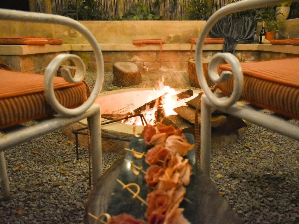 Cozy braai area with active fire pit and comfortable seating chairs